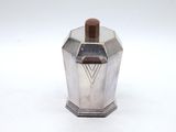 a silver container with a brown handle on a white surface