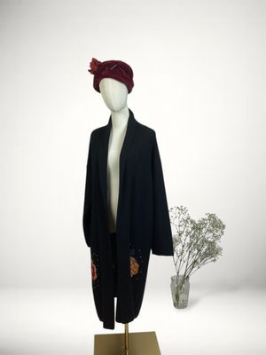 a mannequin wearing a black coat and a red hat