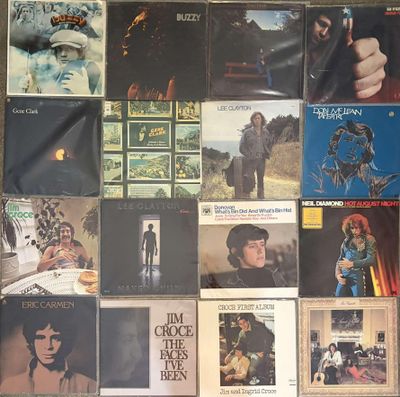 many different album covers on the wall of a room