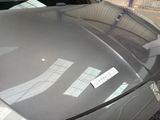 a sticker on the hood of a car that is parked in a parking lot
