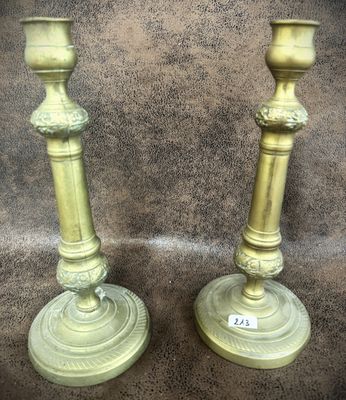 pair of antique brass candlesticks on a brown background