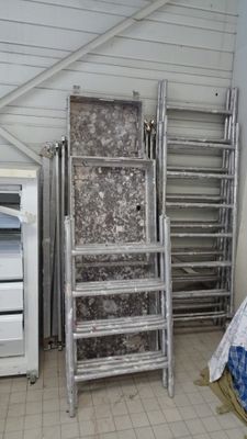 a room with a bed, ladders, and a microwave in it