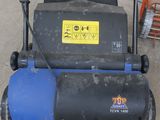 a blue and black lawn mower sitting on the ground