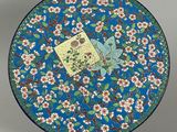 une assiette bleue ornée d'un oiseau et de fleurs