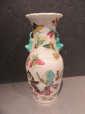 a white vase with a floral design on it on a table