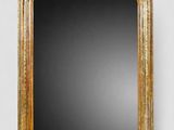 a gold framed mirror on a white wall with a black background