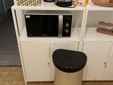 un micro-ondes et une poubelle dans la cuisine