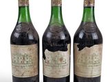 trois bouteilles de vin posées les unes à côté des autres sur une surface blanche