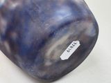 a blue vase with a tag on it sitting on a table