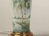 a lamp that is sitting on a table with a painting on it