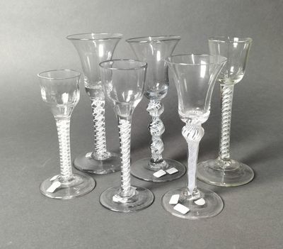 six wine glasses sitting next to each other on a table