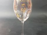 a wine glass sitting on a table with a black background