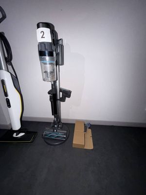 un aspirateur posé sur le sol à côté d'une boîte