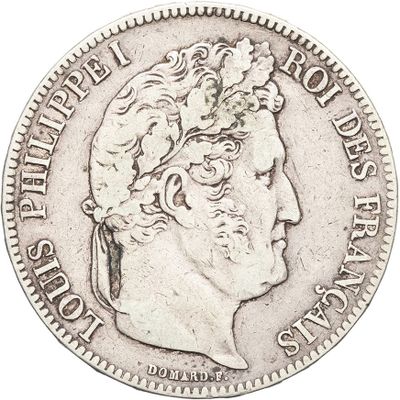 a silver coin with a man ' s head on it