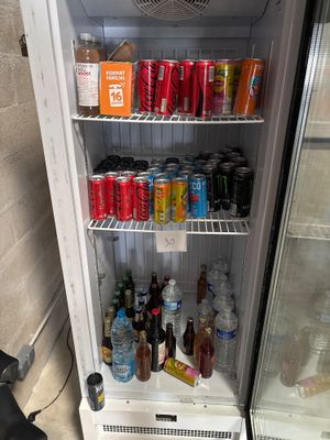 un réfrigérateur qui contient beaucoup de boissons et de sodas