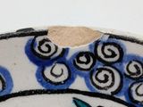 a close up of a bowl with a bird and flowers on it
