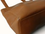 leather handbag on a white background with a blue and white logo