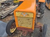 an orange tractor that is parked on the side of the road