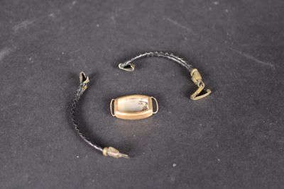 un bracelet avec un fermoir doré sur un fond noir
