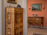 a wooden cabinet in the middle of a room with a rug on the floor