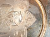 a close up of a silver plate with a design on it