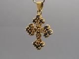 un gros plan d'un pendentif en forme de croix en or suspendu à une chaîne