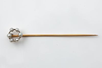 a close up of a metal pin with pearls on it