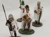 four figurines of people dressed in medieval clothing