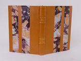 an orange leather book with a marbled cover on a white background