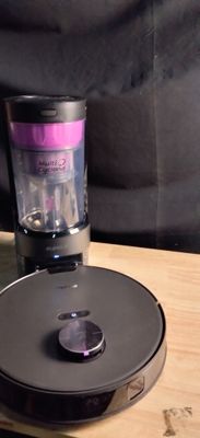 un mixeur posé sur une table en bois, à côté d'une tasse