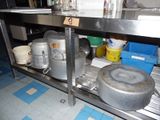 many pots and pans on the shelf in the kitchen