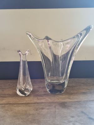 two glass vases sitting on a table next to each other