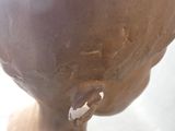 a clay sculpture of a head with a hole in the middle