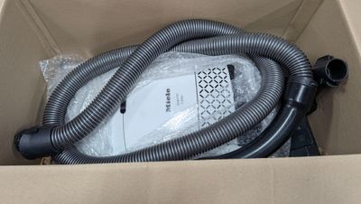 une boîte contenant un aspirateur et un tuyau