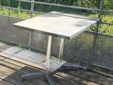 a small table on a wooden deck with a fence in the background