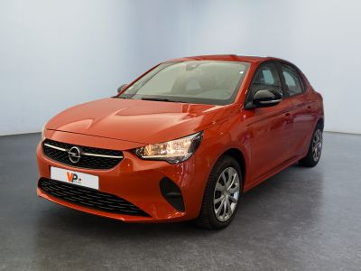 La voiture orange est garée dans une grande pièce.