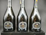 trois bouteilles de champagne posées sur un bloc de bois