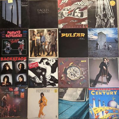 many different album covers on the wall of a room