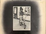 an old black and white photo of a man on a tricycle