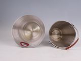 a silver cup with a red handle next to a silver cup with a red handle