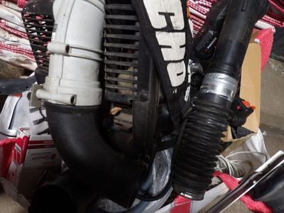 une image représentant un moteur de moto auquel est raccordé un tuyau