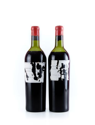 deux bouteilles de vin rouge posées l'une à côté de l'autre sur une surface blanche