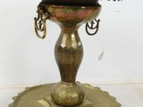 a brass plate with a candle holder on it