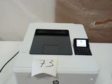une imprimante blanche posée sur une table, sur laquelle se trouve un téléphone portable
