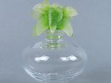un petit vase en verre contenant une fleur verte