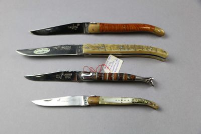 four knives are lined up in a row on a table