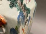 a vase with a bird on it sitting on a table