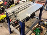 une table sur laquelle est posée une scie, dans un atelier