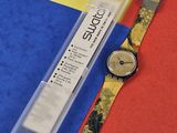 une montre posée sur une feuille de papier, à côté d'un stylo