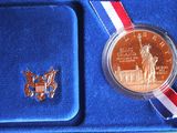 a coin in a blue box with a red, white, and blue ribbon around it